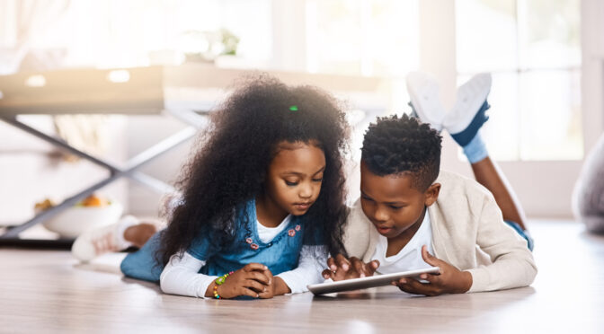 Shot of two adorable little siblings using a digital tablet together at home